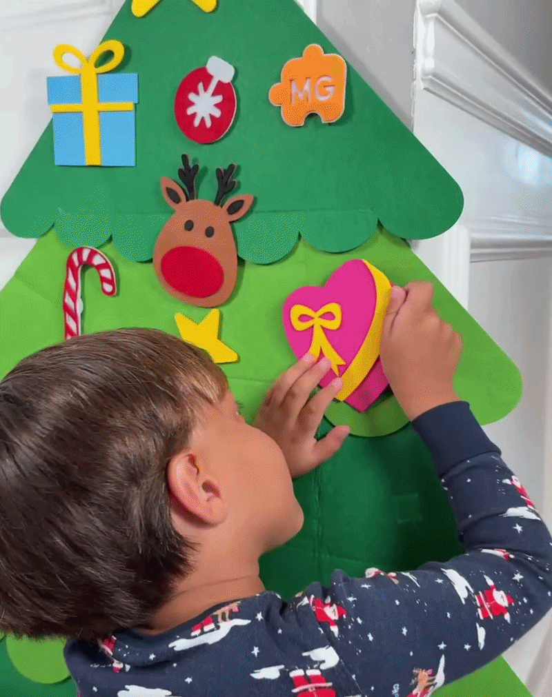 Kind schmückt den Filz-Weihnachtsbaum
